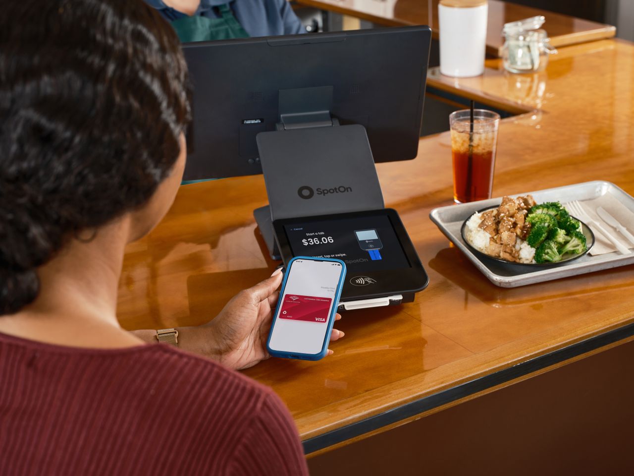 Services A customer uses mobile payment at a restaurant counter with SpotOn POS.
